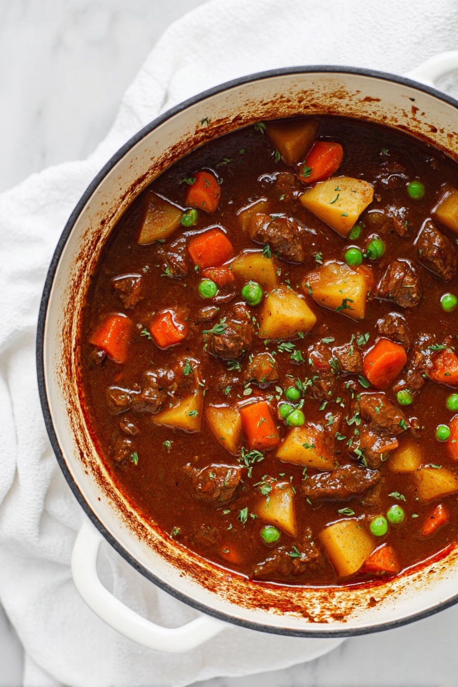 A white bowl filled with thick beef stew showing three layers: the top layer is bright orange carrot slices and green peas, the middle layer contains chunks of yellow potatoes and pieces of brown beef, and the bottom layer is a rich dark brown broth with visible herbs sprinkled on top; the bowl is placed on a white marbled surface with a white cloth and a silver spoon nearby, and there are small clear bowls with green herbs and pepper flakes in the background, photo taken with an iphone --ar 2:3 --v 7